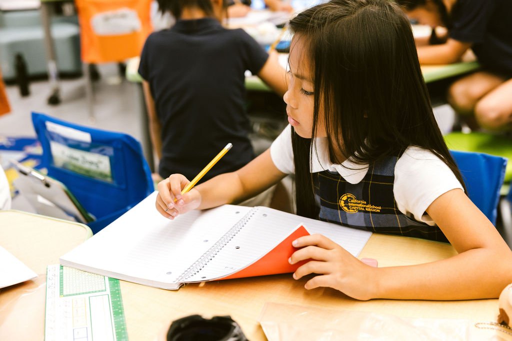 a girl student writing on her book